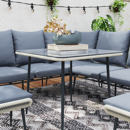 Garden sofa set close-up with grey cushions and rounded glass-top table