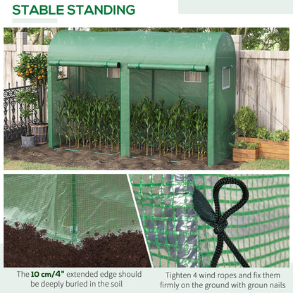 Green walk-in greenhouse with plants inside, roll-up doors and window openings.