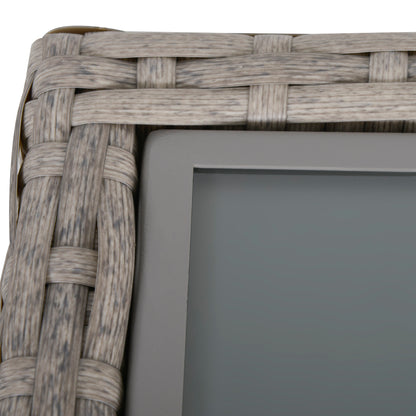 Gray wicker table corner with dark glass inset and woven rattan edging