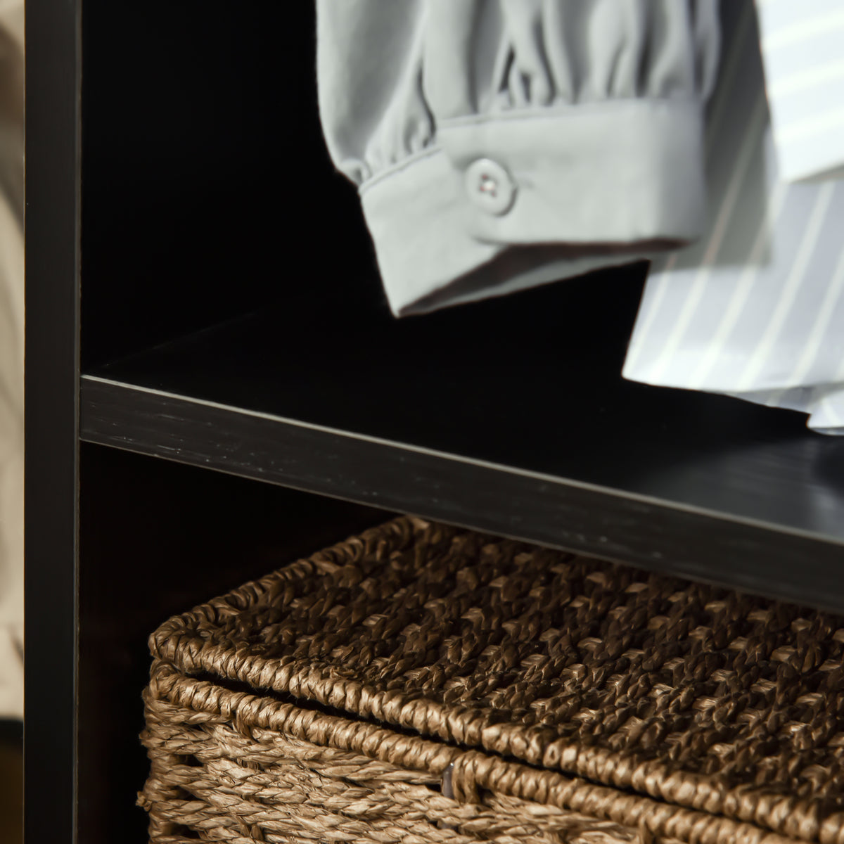 Wardrobe shelf beneath hanging clothes, shown with a woven storage basket