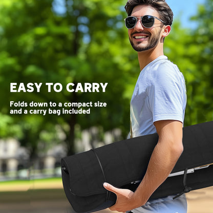 Folded black camping chair carried by hand; a carry bag is included