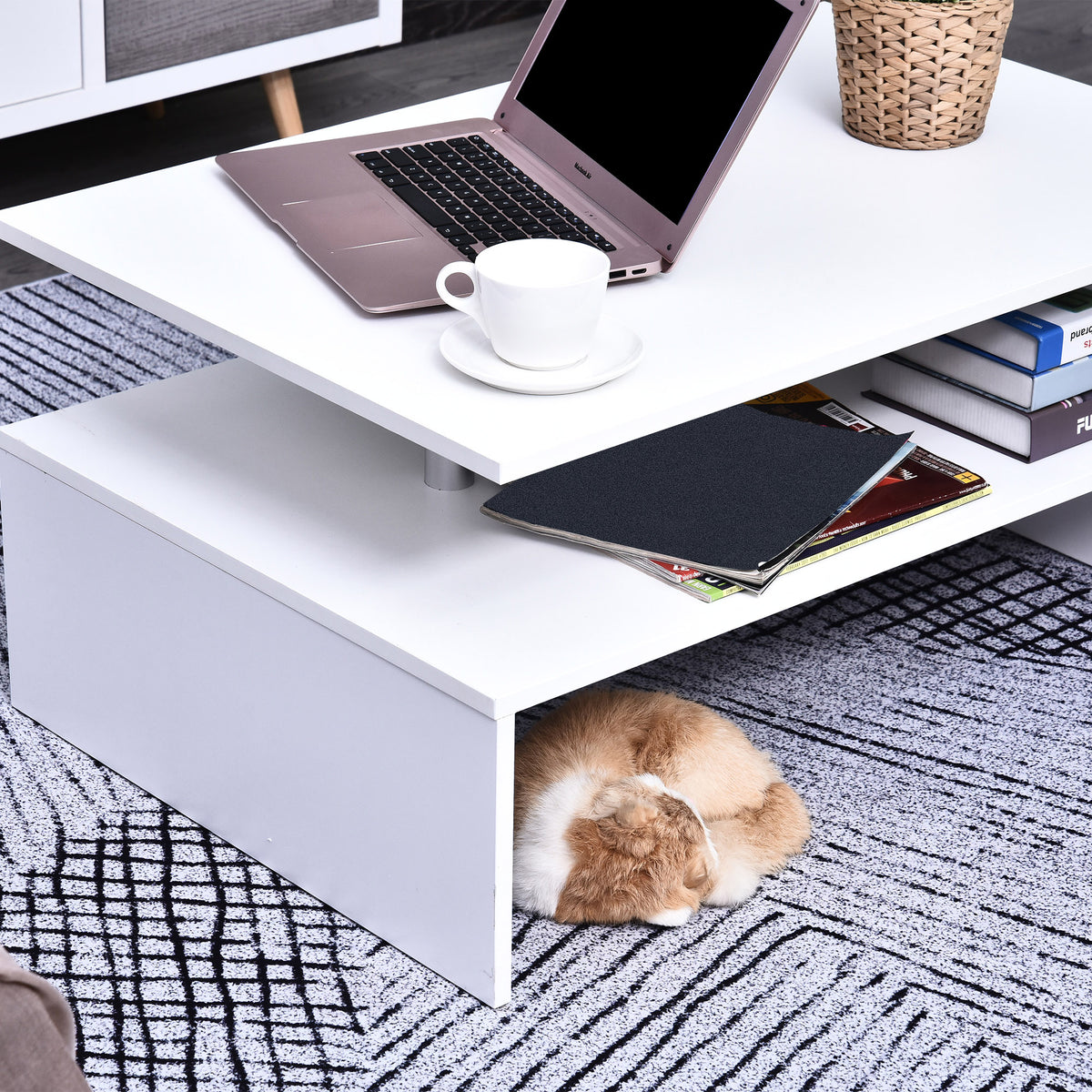 White two-tier coffee table used as a work surface with laptop and open storage shelf
