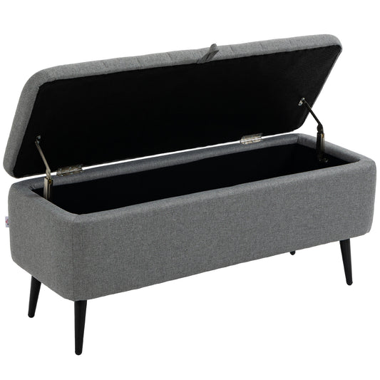 Grey upholstered storage bench with raised lid, black interior and steel legs