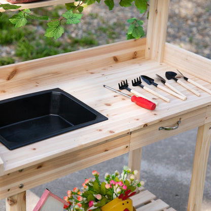 Wooden potting bench worktop with black sink, hand tools, and front drawer