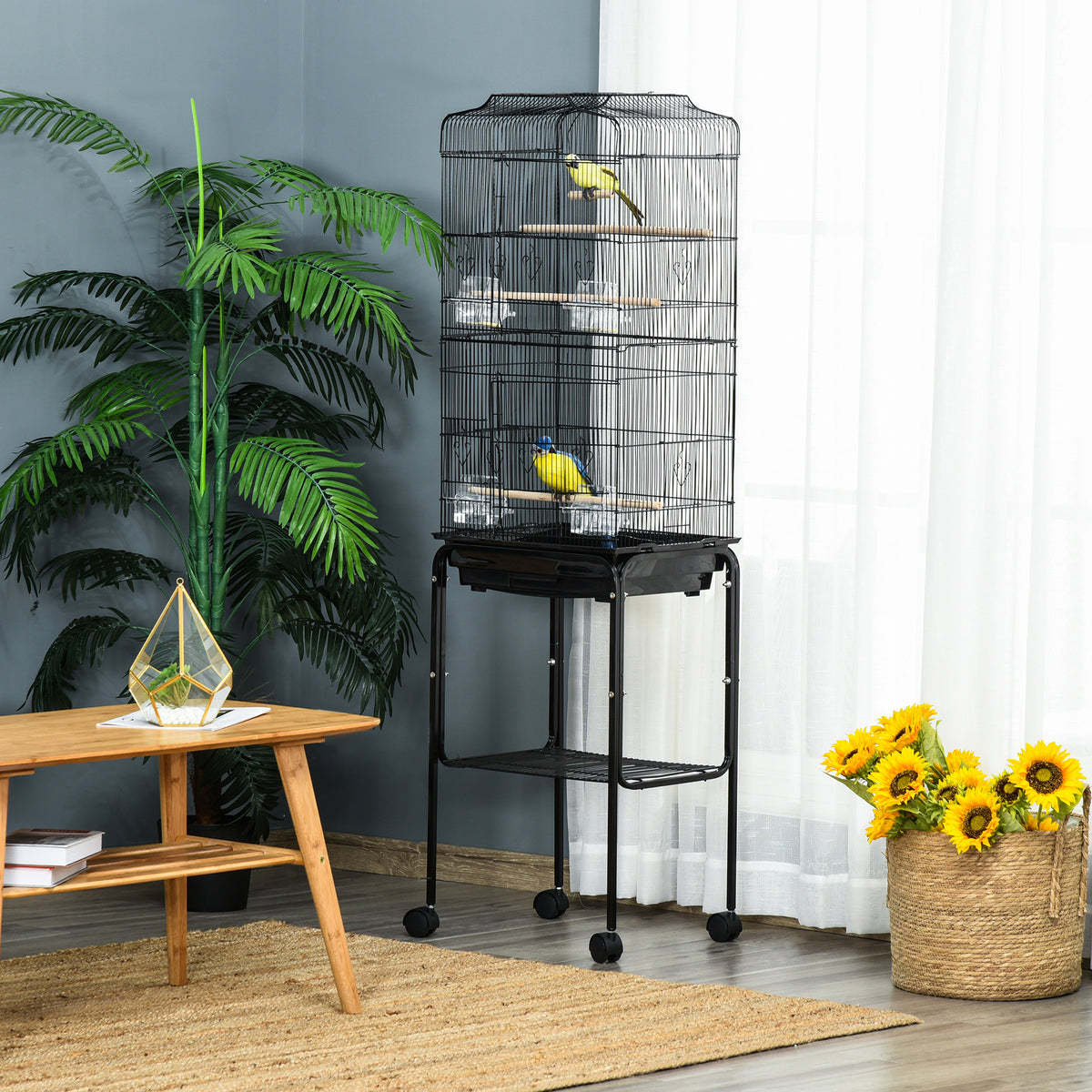 Black bird cage on a wheeled stand with two birds perched inside