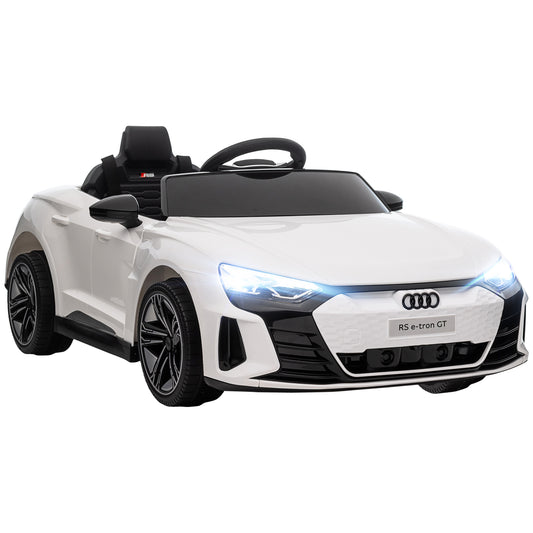 Front three-quarter view of white Audi kids' ride-on car with illuminated headlights