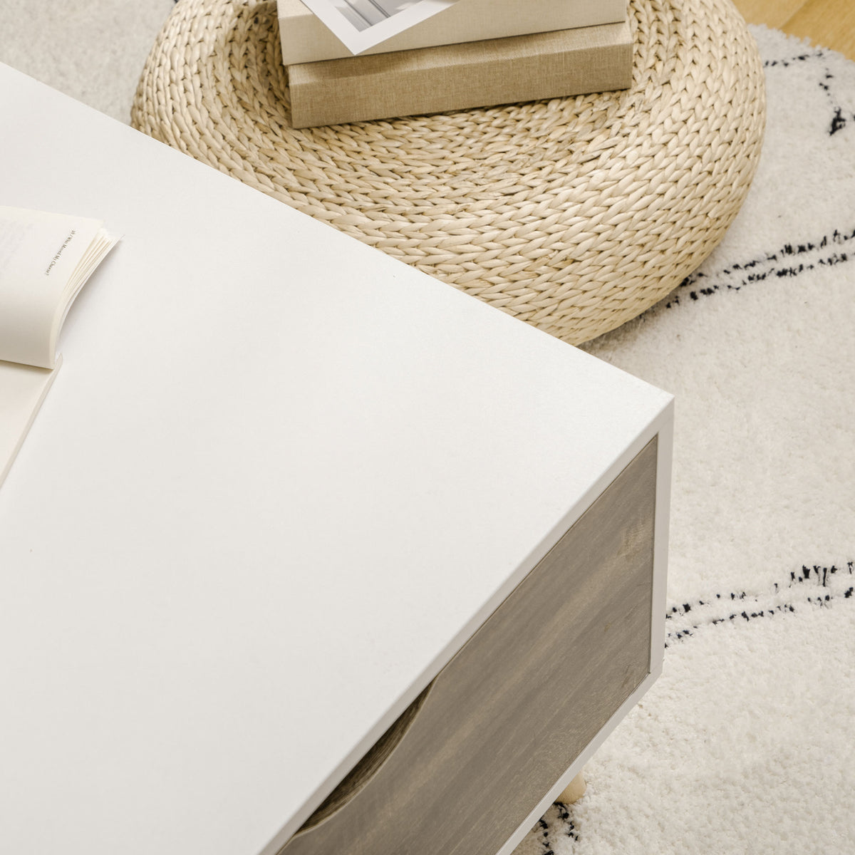 Coffee table corner showing the white top and wood-grain drawer front
