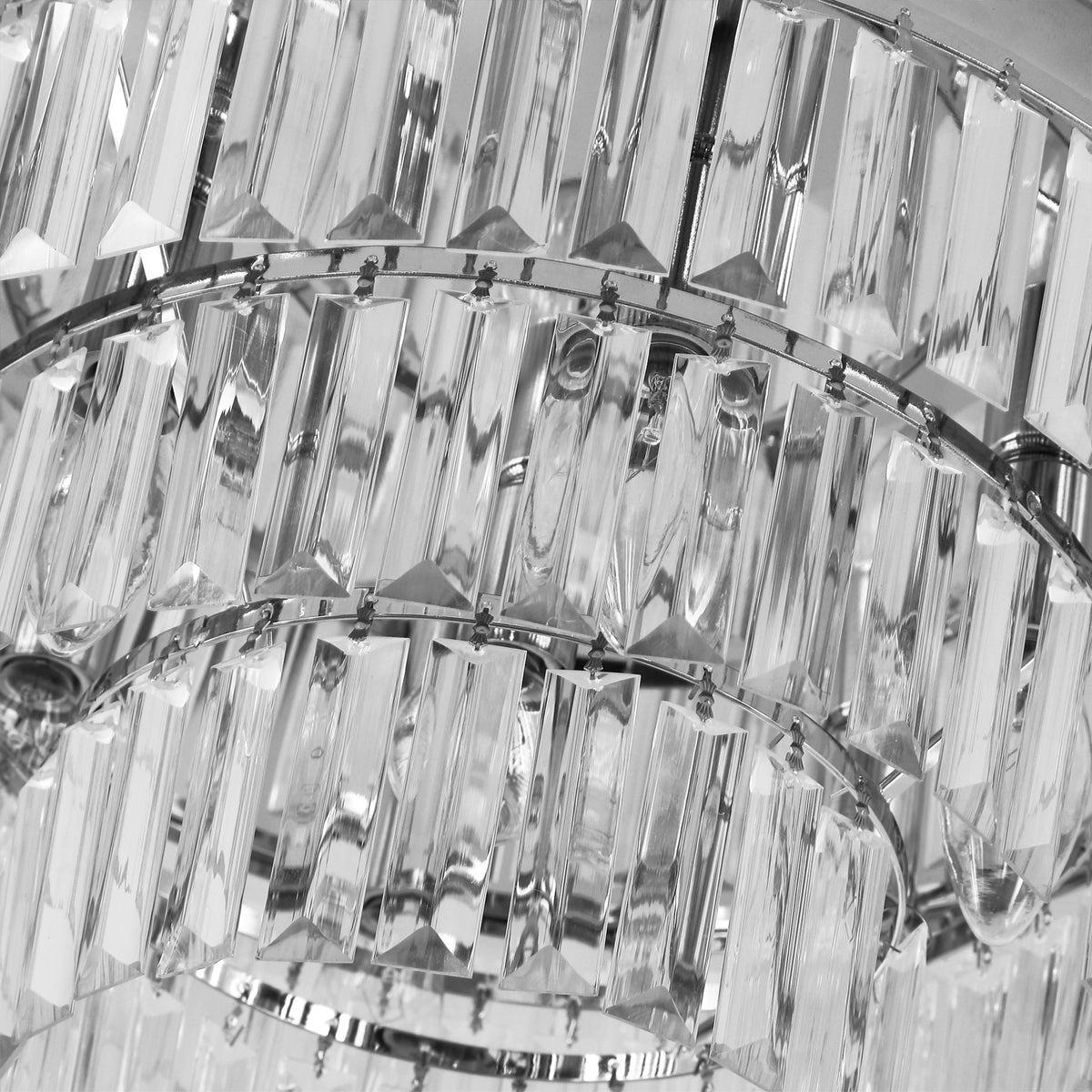 Close-up of faceted clear crystal drops and metal rings on the chandelier