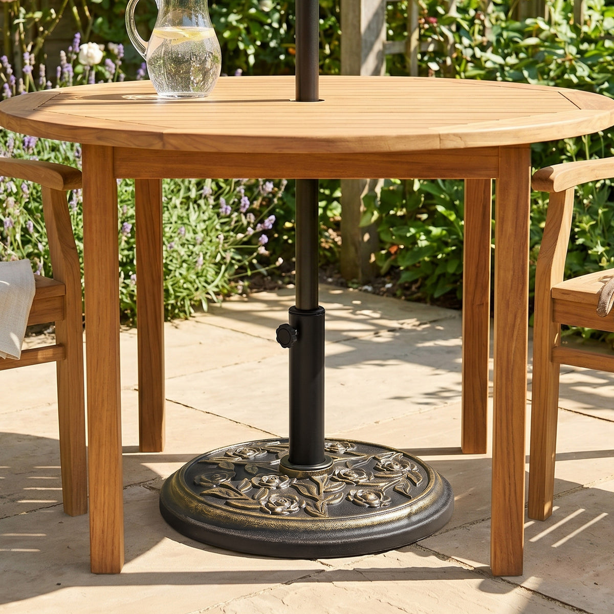 Floral parasol base holding a pole beneath a wooden patio table